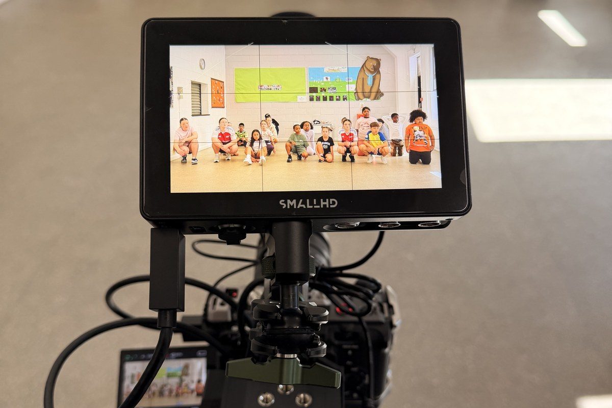 A cinema camera and production monitor on a Warriorz shoot, with dancers visible on the monitor